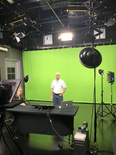 Guy standing in front of a green screen